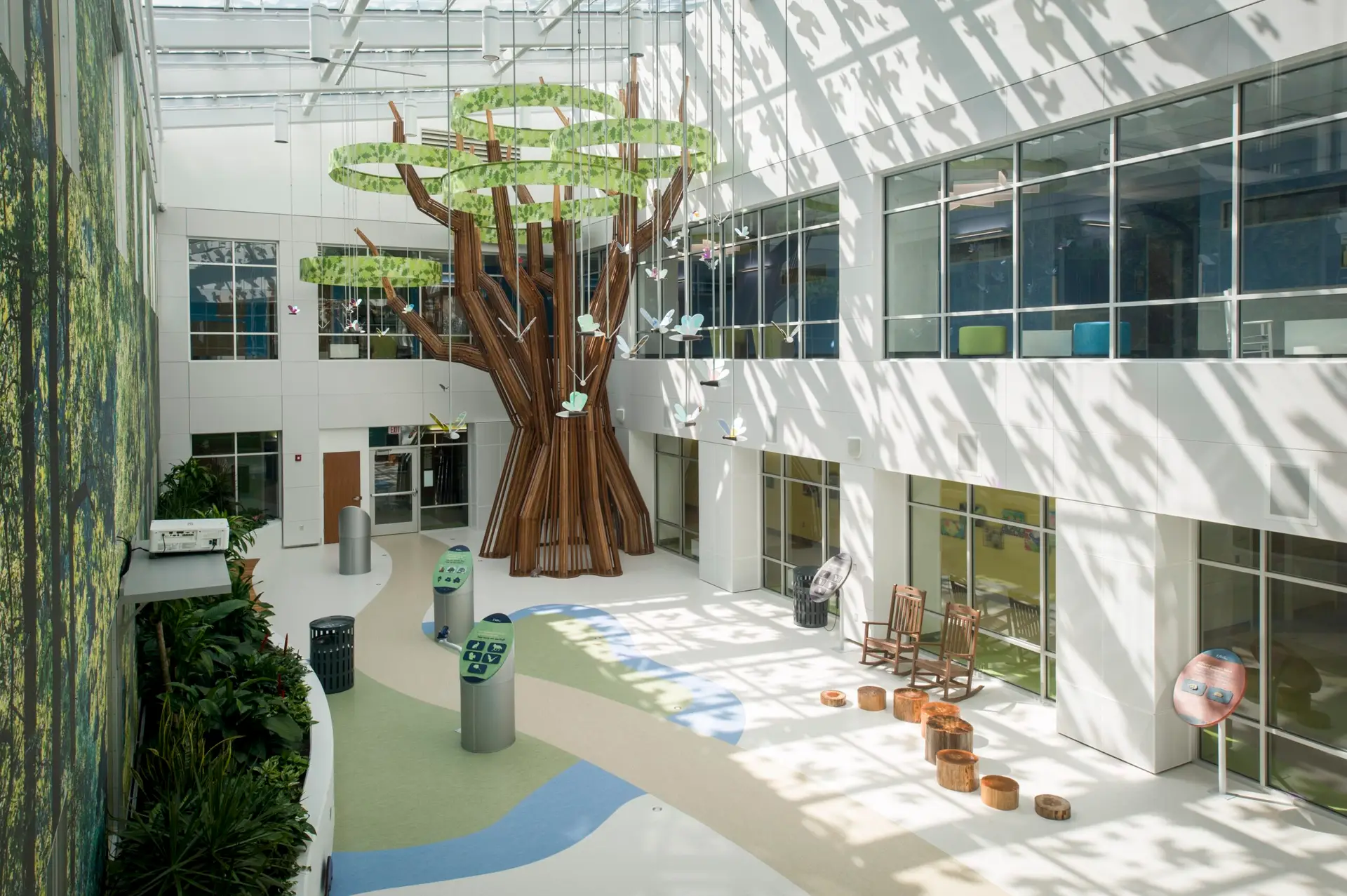 A large, minimalist metal tree towers 3-stories high in the sunlit atrium of Beacon Children's Hospital