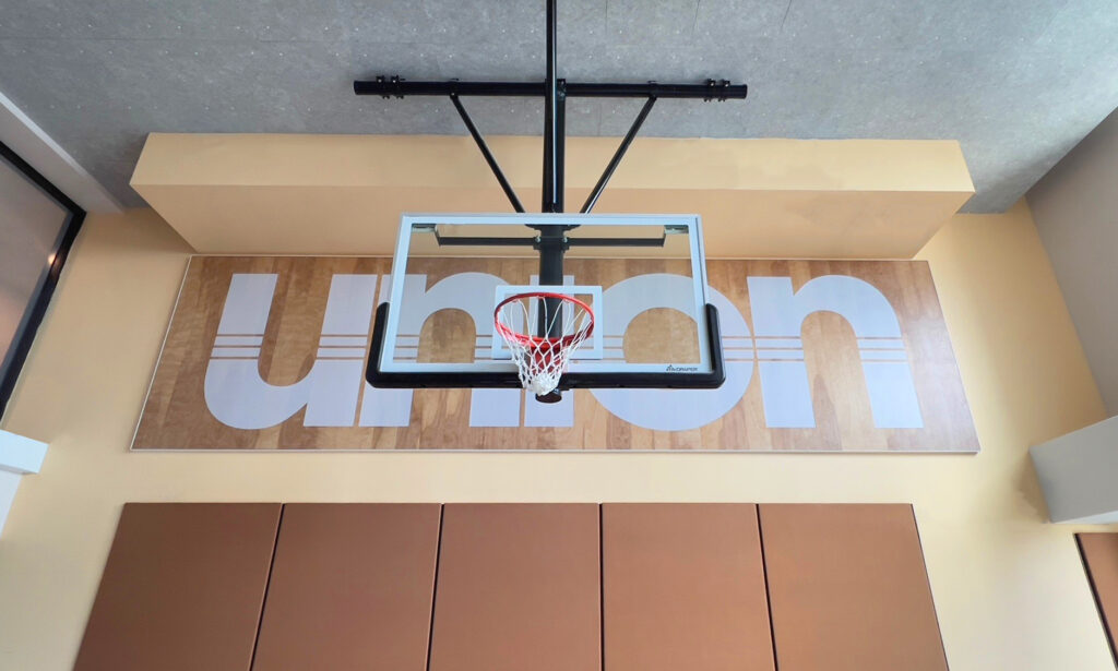 Wall-to-wall Union logo mounted in the basketball court at Union on 24th