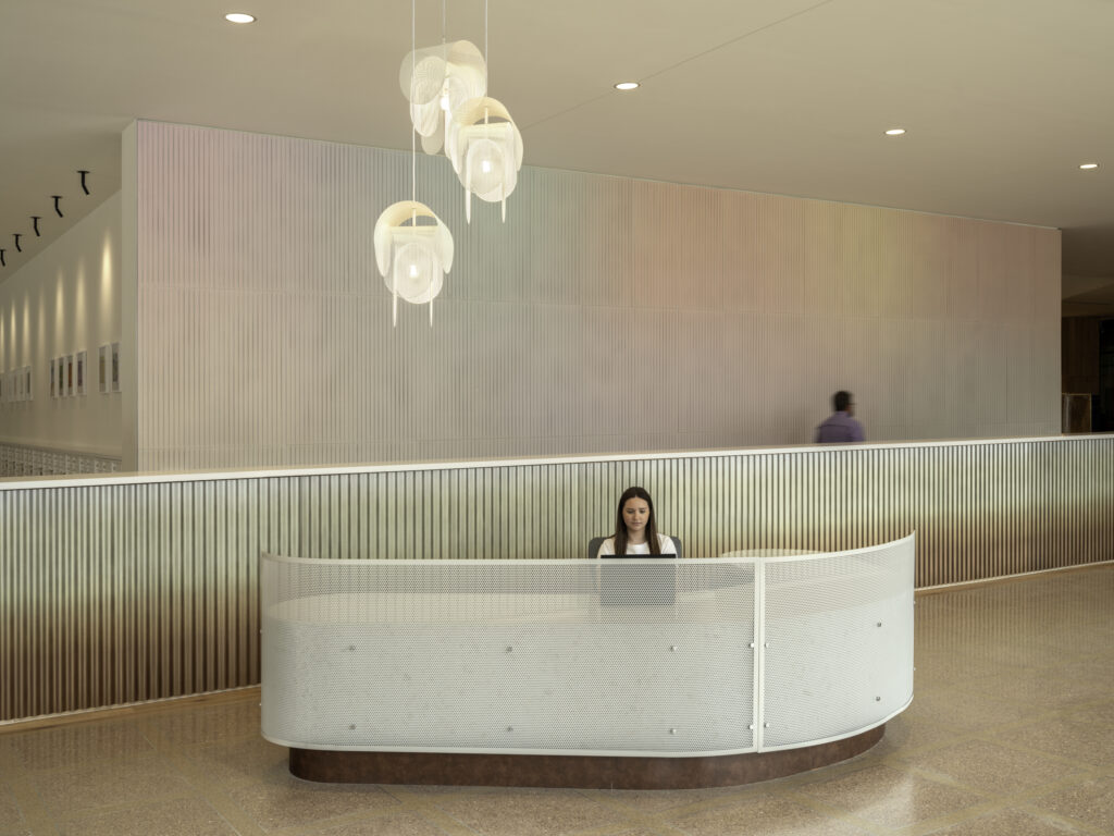 Gentle rainbow gradient behind front desk of Union on 24th lobby